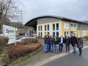 Foto: Landrat Achim Hallerbach (3. von rechts) und Bürgermeister Volker Mendel (rechts) zeigten sich beim Besuch des Syna-Zentrallagers in Urbach beeindruckt und begrüßten die Erweiterungspläne.