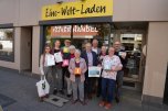 Vor dem Eine-Welt-Laden in der Neuwieder Innenstadt freuen sich Landrat Achim Hallerbach, Oberbürgermeister Jan Einig, die Steuerungsgruppe der Fairtrade-Stadt Neuwied sowie Ehrenamtliche des Eine-Welt-Ladens über die Aktionen in der Fairen Woche. Foto: Nadine Schöneberg / Stadtverwaltung Neuwied