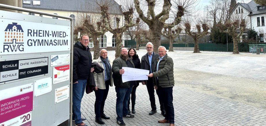 Landrat Achim Hallerbach, der 1. Kreisbeigeordnete Phillip Rasbach und Martin Wagner vom Kreis-Immobilienmanagement machten sich gemeinsam mit Schulleiter Helmut Zender und der stellvertretenden Schulleiterin Christine Hahn ein Bild von der klimafreundlichen Umwandlung des RWG-Schulhofs. Foto: Thomas Herschbach