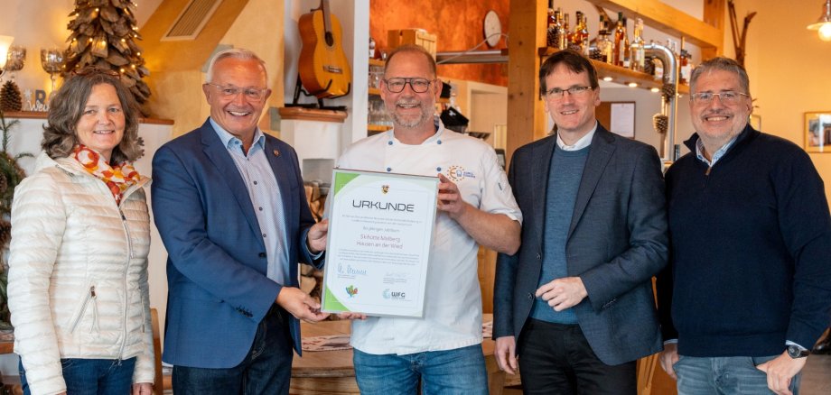 Landrat Achim Hallerbach, Kreiswirtschaftsförderer Harald Schmillen, Naturgenuss-Projektleiter Jörg Hohenadl und die Ortsbürgermeisterin von Hausen, Carmen Boden, gratulierten Jürgen Hühner und dessen Team zu 60 Jahren Skihütte. Foto: Martin Boden / Kreisverwaltung Neuwied