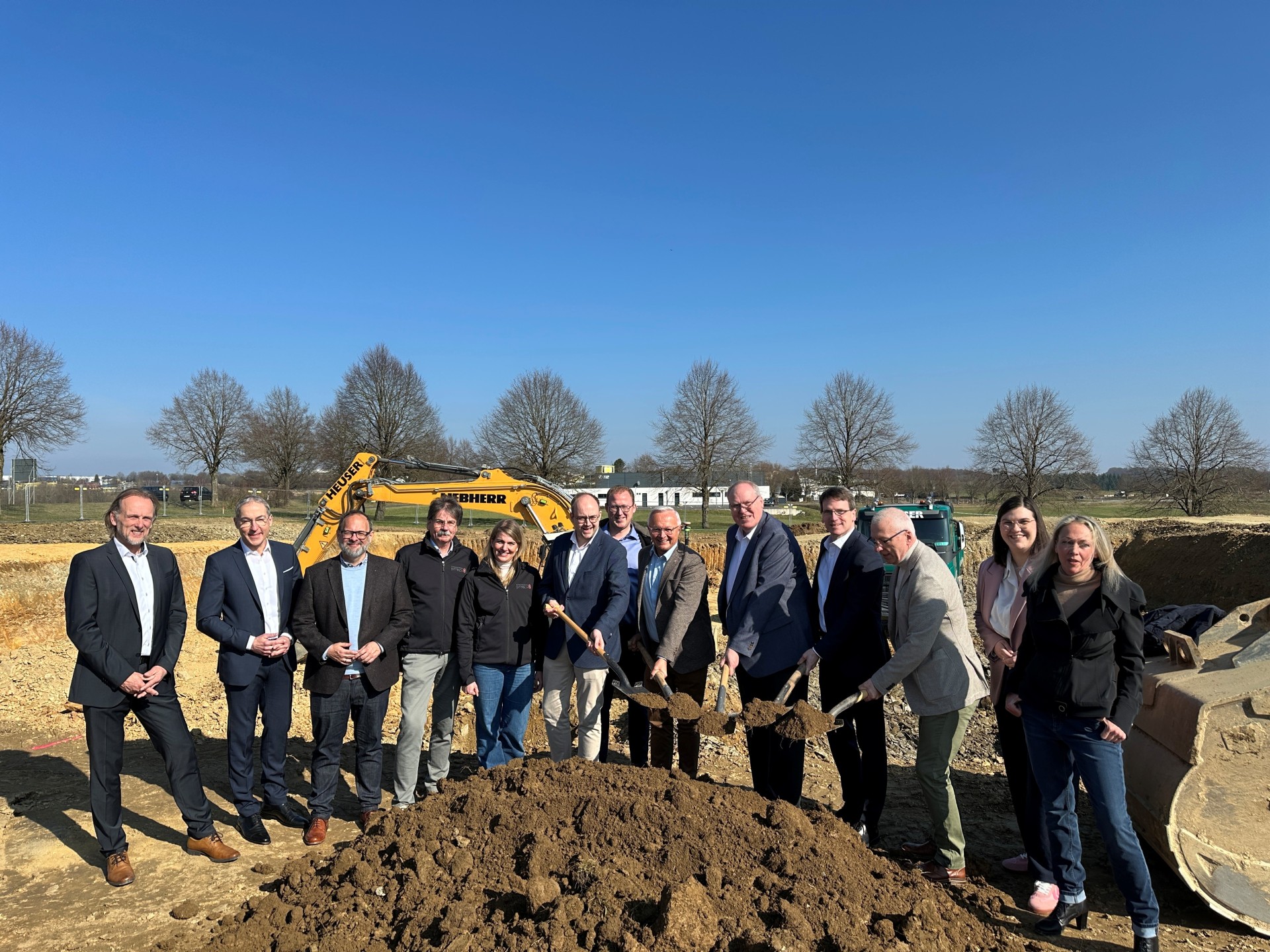 Foto-Unterzeile: Bestes Wetter beim offiziellen Spatenstich. Über beides freuen sich (von links nach rechts): Uwe Schmidt (Geschäftsführer R quadrat und RSC), Willi Krannich, Jan Petry CDU, Ingo Dittrich mit Tochter (Planungsbüro Dittrich), Bürgermeister Pierre Fischer (VG Rengsdorf-Waldbreitbach, 1. Kreisbeigeordneter Philipp Rasbach, Landrat Achim Hallerbach, Uwe Reifenhäuser (Bauherr), Harald Schmillen (Wirtschaftsförderung Landkreis Neuwied), Ortsbürgermeister Holger Drees, Marie-Christin Ockenfels, SPD, und Jessica Reifenhäuser. Foto: Thomas Herschbach