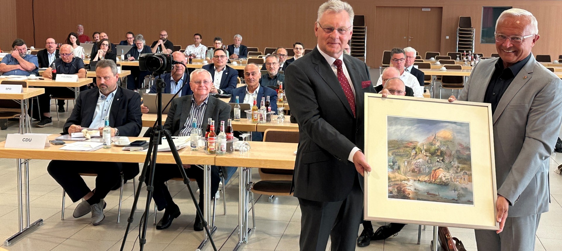 Als äußeres und sichtbares Zeichen von Dank und Anerkennung überreichte Landrat Achim Hallerbach dem scheidenden Kreistagsmitglied Viktor Schicker ein Aquarell des Niederhofener Künstlers Reinhard Zado mit Motiven aus dem gesamten Landkreis Neuwied. Foto: Thomas Herschbach