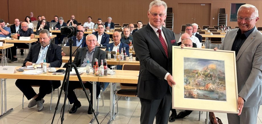 Als äußeres und sichtbares Zeichen von Dank und Anerkennung überreichte Landrat Achim Hallerbach dem scheidenden Kreistagsmitglied Viktor Schicker ein Aquarell des Niederhofener Künstlers Reinhard Zado mit Motiven aus dem gesamten Landkreis Neuwied. Foto: Thomas Herschbach Als äußeres und sichtbares Zeichen von Dank und Anerkennung überreichte Landrat Achim Hallerbach dem scheidenden Kreistagsmitglied Viktor Schicker ein Aquarell des Niederhofener Künstlers Reinhard Zado mit Motiven aus dem gesamten Landkreis Neuwied. Foto: Thomas Herschbach