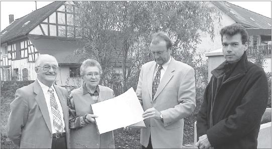 Foto: Der Landrat und die edle Spenderin Hedwig Runkel. Die beiden werden eingerahmt von Karl Henn (links) und Dr. Reinhard Lahr. Die Gruppe hat sich übrigens vor dem Geburtshaus (links) der Rentnerin aus Thalhausen postiert. Foto: Ralf Brockmeier