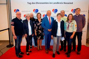 Foto: Mit Herz und Hand – so symbolisierte schon das Logo des Abends im vollbesetzten  Bürgerhaus St. Katharinen das Motto des ersten Ehrenamtsdankabends des Landkreises Neuwied, zu dem Landrat Achim Hallerbach eingeladen hatte. Für rund 200 Gäste hatte die Kreisverwaltung im wahrsten Sinne des Wortes den roten Teppich ausgerollt, um Frauen und Männern aus allen Sparten des Ehrenamtes Dank und Anerkennung zu zollen. Es gab u.a. zwei Talkrunden mit sechs Vereinsvertretern, die von ihrem ehrenamtlichen Engagement in den verschiedensten Ehrenamtssparten berichteten. (v.l.n.r.): Helmut Hecking (St. Sebastianus Schützenbruderschaft Rahms), Anita Trostel (Niederbieberer Bürgerverein), Julian Wagner (Männergesangverein Dernbach), Kerstin Schanbeck-Stephan (Kreisverwaltung Neuwied), Landrat Achim Hallerbach, Martina Gonser (Moderatorin), Eberhard Schneider (Arbeitsgemeinschaft Kulturlandschaft Leutesdorf), Susanne Hachemer (Pfadfinderstamm St. Bonifatius Oberbieber), Philipp Stuntz (HSG Römerwall Bad Hönningen/Rheinbrohl).