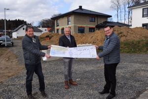 Foto: Im Windhagener Ortsteil Rederscheid beginnen die Arbeiten für den zweiten Abschnitt zur Erschließung des Baugebiets Rellensiefen. V.r.n.l. SWN-Chef Stefan Herschbach, Landrat Achim Hallerbach und SWN-Geschäftsfeldleiter Thomas Endres mit den Plänen für den Ausbau.