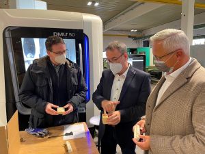 Foto: Hans Dieter Spohr, Projektleiter und „Problemlöser“ der Kern GmbH, (Mitte) führte Landrat Achim Hallerbach (rechts) und Kreis-Wirtschaftsförderer Harald Schmillen durch die Produktionshallen des Kunststoffteileherstellers. 