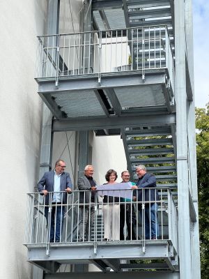 Der Abteilungsleiter des Immobilienmanagements Rüdiger David, Landrat Achim Hallerbach, die zuständige Projektleiterin des Immobilienmanagements, Katrin Weiß, Hausmeister der IGS, Hans-Jürgen Schmitz und der 1.Kreisbeigeordnete Michael Mahlert bei einer Baubesprechung auf der neuen Fluchttreppe am Haus ROT. Im Falle einer Evakuierung ermöglicht die Treppe eine sichere und schnelle Flucht. 