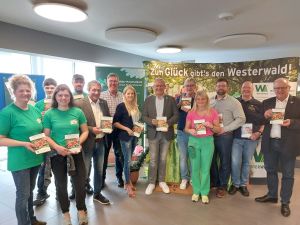 Foto: Myriam Hatzmann (Wir Westerwälder) Bildunterschrift: Gemeinsam mit den regionalen Erzeugern wird der neue Einkaufsführer vorgestellt (v.l.n.r.): Familie Müller (Hof Bölsbach, Hattert), Achim Schwickert (Landrat Westerwaldkreis), Klaus Strüder (Westerwald-Brauerei, Hachenburg), Gestaltung bei Carina Schäfer (CARINA Werbung & Design, Elkenroth), Achim Hallerbach (Landrat Kreis Neuwied), Guido Schmitz (Westwood Icecream, Deesen), Sandra Köster (Wir Westerwälder), Benjamin Junge (Privatkelterei Junge, Gieleroth), Arne Senck (Honigmanufaktur Senck, Dürrholz), Dr. Peter Enders (Landrat Kreis Altenkirchen). 