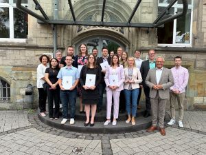 Foto: Vor dem Kreishaus platziert möchten sie sich im Kreishaus für den Landkreis Neuwied weiter einbringen: die neun frisch ernannten Mitarbeiterinnen und Mitarbeiter der Kreisverwaltung mit Landrat Achim Hallerbach und der Verwaltungsspitze. Foto: Thomas Herschbach