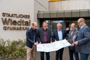 Foto: Beim Termin vor Ort (von rechts nach links): Rüdiger David, Abteilungsleiter des Immobilienmanagements der Neuwieder Kreisverwaltung, Schulleiter Thorsten Mehlfeldt, Landrat Achim Hallerbach, der Erste Kreisbeigeordnete Philipp Rasbach und Florian Kropf vom Immobilienmanagement des Kreises werfen einen Blick auf die geplanten Baumaßnahmen am Wiedtal Gymnasium in Neustadt/Wied. Foto: Martin Boden / Kreisverwaltung Neuwied.