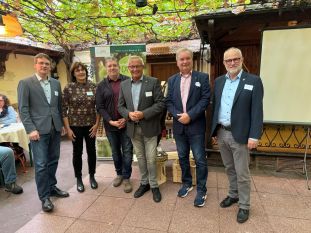 Der rebenumrankte und mit reifen Trauben besetzte Innenhof des Weinhauses „Zur Traube“ bildete den passenden Rahmen für das mittlerweile 4. Touristische Netzwerktreffen der Wirtschaftsförderung im Landkreis Neuwied GmbH. Landrat Achim Hallerbach sowie (von links) WFG-Geschäftsführer Harald Schmillen, Naturpark-Geschäftsführerin Irmgard Schröer und Naturgenuss-Projektleiter Jörg Hohenadl konnten dazu auch (von rechts) Alfons Mußhoff, Stadtbürgermeister von Unkel, und den Bürgermeister der Verbandsgemeinde Unkel, Karsten Fehr, begrüßen. Foto: Vanessa Selent