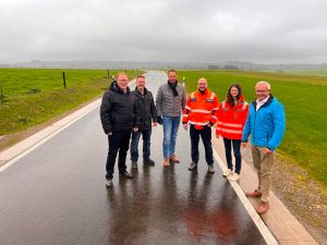 Foto: Von links nach rechts: Der Erste Kreisbeigeordnete Philipp Rasbach, Ortsvorsteher Marcel Jüttner, Bürgermeister der VG Dierdorf Manuel Seiler, Stellvertretender Leiter Masterstraßenmeisterei Neuwied, LBM, Sebastian Görlitz, Christina Junk (Immobilienmanagement der Kreisverwaltung Neuwied) und Landrat Achim Hallerbach beim Ortstermin auf dem neuen Teilstück der K 124. Foto: Martin Boden / Kreisverwaltung Neuwied.