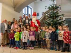 Foto: Die Vorschulkinder aus Melsbach, begleitet von Kita-Leiterin Annika Wolff und Team, brachten Weihnachtliche Stimmung in die Neuwieder Kreisverwaltung. Büroleiterin Diana Wonka, Landrat Achim Hallerbach, Sebastian Grobbel (Forstrevierleiter Straßenhaus), Thomas Paffenholz (Sparkasse Neuwied), Hans-Werner Breithausen (Bürgermeister Rengsdorf-Waldbreitbach), Wolfgang Klein (Ortsgemeinderat Melsbach) und der Erste Kreisbeigeordnete Philipp Rasbach als Nikolaus freuen sich über die prächtig geschmückte Tanne. Foto: Martin Boden 