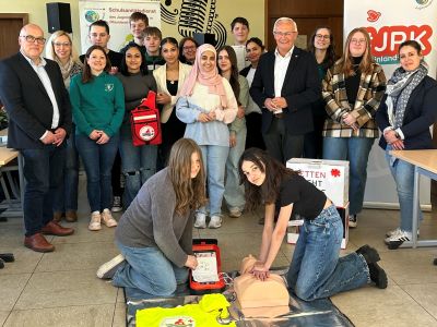  „Learning by doing (and teaching): Landrat Achim Hallerbach machte sich in der Robert-Krups-Schule im Neuwieder Stadtteil Irlich mit Schulleiter Peter Kowalenko selbst ein Bild vom Schulsanitätsdienst. Foto: Thomas Herschbach