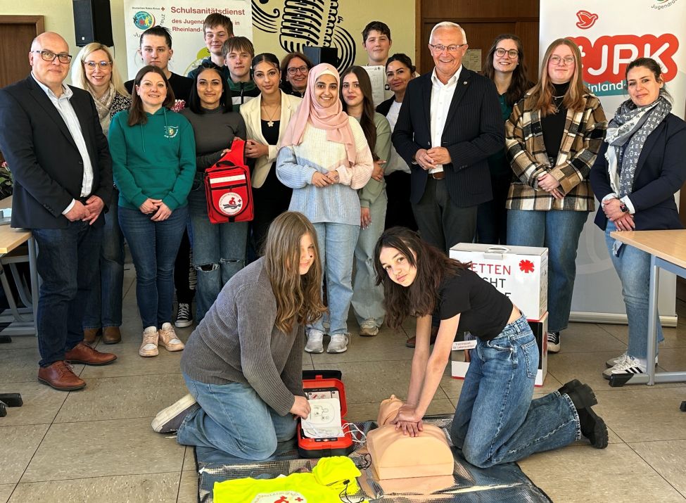  „Learning by doing (and teaching): Landrat Achim Hallerbach machte sich in der Robert-Krups-Schule im Neuwieder Stadtteil Irlich mit Schulleiter Peter Kowalenko selbst ein Bild vom Schulsanitätsdienst. Foto: Thomas Herschbach