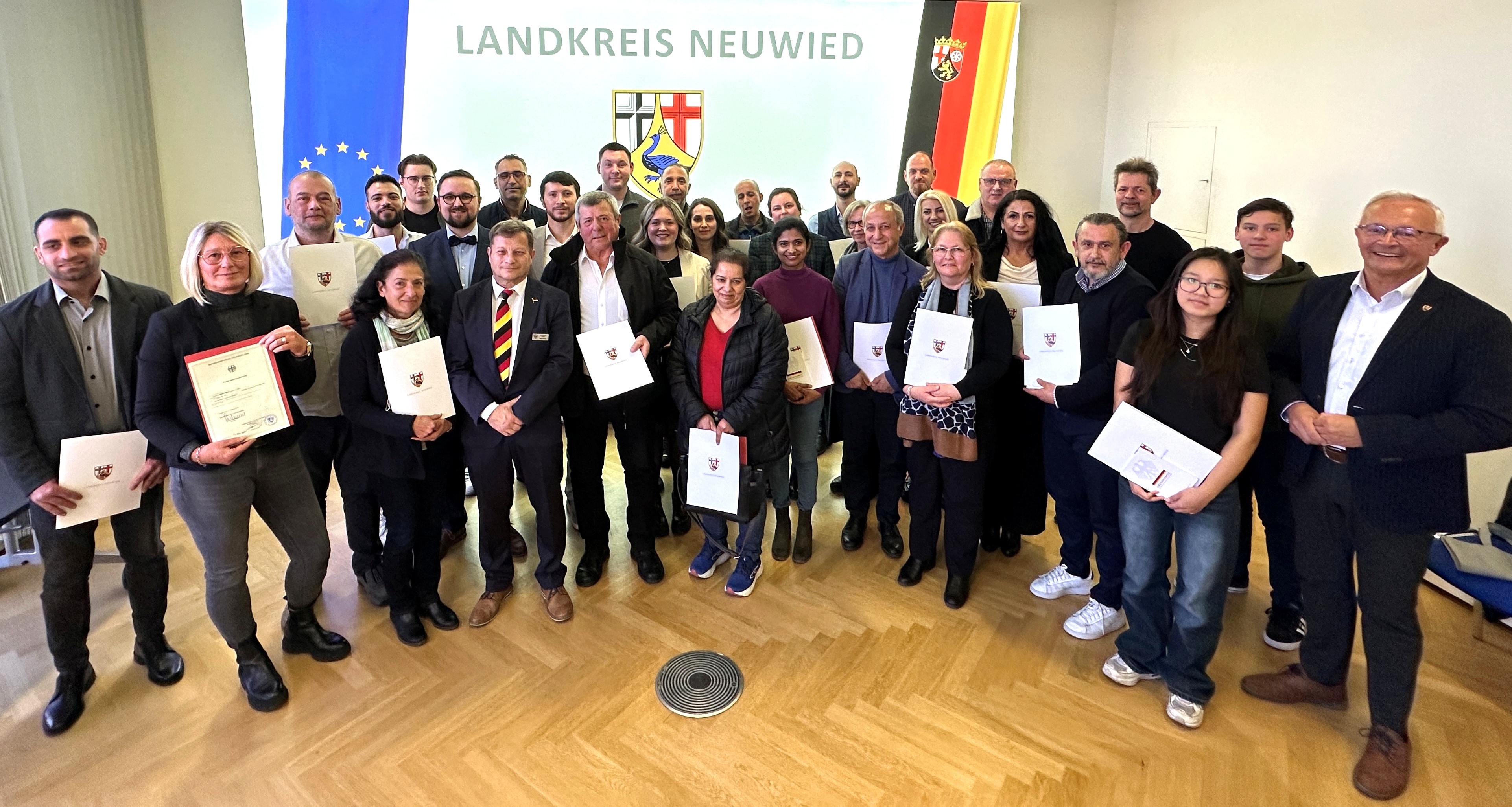 Foto: Noch vor den Festtagen konnte Landrat Achim Hallerbach im Max-zu-Wied-Saal des Kreishauses 26 Frauen und Männern eine besondere Frühlingsfreude bereiten: Die Verleihung der deutschen Staatsbürgerschaft. Foto: Thomas Herschbach