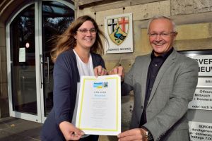 Foto: Der Landkreis Neuwied erfüllt weiterhin alle fünf Kriterien der Fairtrade-Towns Kampagne und trägt nun für weitere zwei Jahre den Titel Fairtrade-Landkreis. Landrat Achim Hallerbach und Gabi Schäfer von der Stabsstelle Energie, Klima, Umwelt bei der Kreisverwaltung freuen sich über die Verlängerung des Titels.