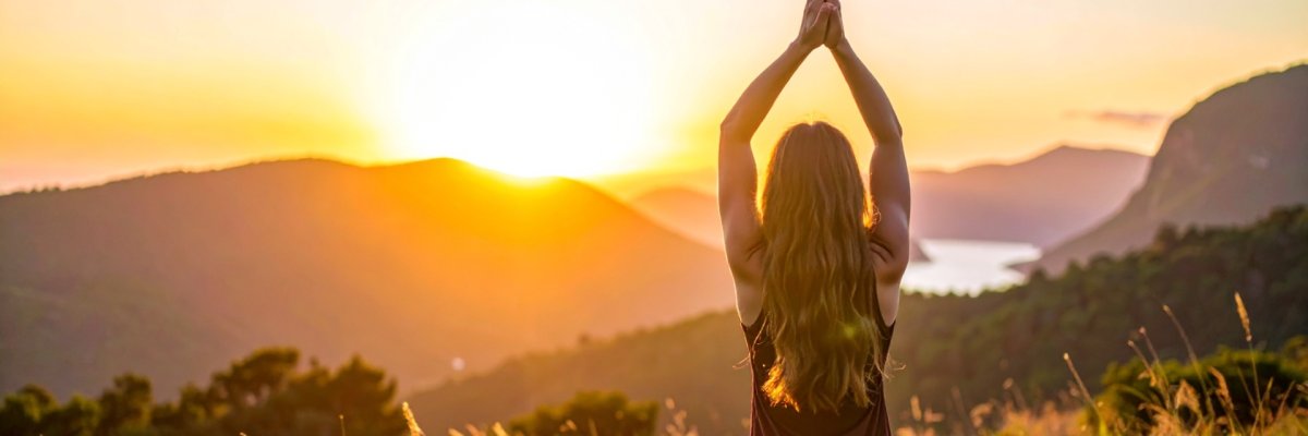 Frau macht vor einem Sonnenuntergang Yoga