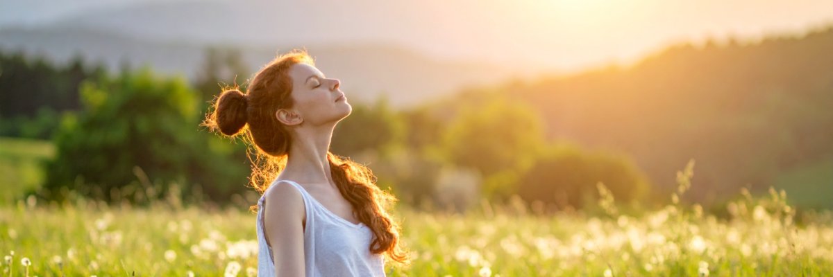 Frau macht Yoga auf einer grünen Wiese