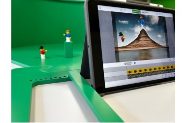 Eine grüne Kunststofffläche ist zu sehen auf der 2 Playmobilfiguren stehen. Davor steht ein Laptop, auf dem die Szene der beiden Figuren abgebildet wird.
