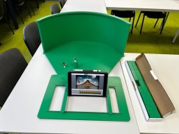 Ein Greenscreen steht auf einem Tisch.